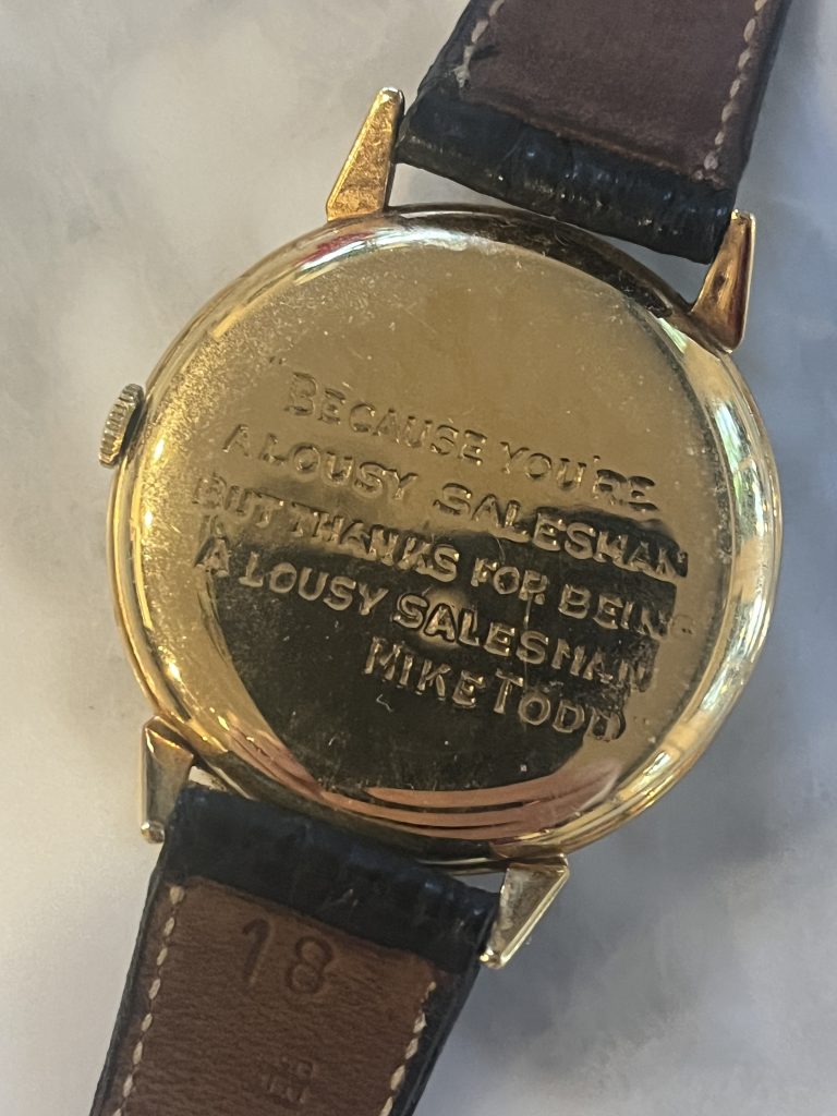 The rear of a watch given to Hal Scott by Mike Todd inscribed "Because you're a lousy salesman but thanks for being a lousy salesman"